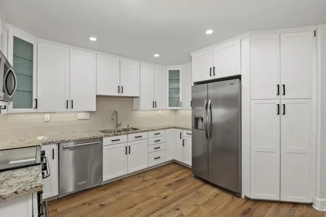 a kitchen with granite countertop a refrigerator and a sink