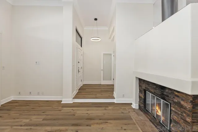 a view of a hallway with wooden floor and a bathroom