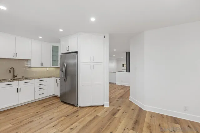 a kitchen with granite countertop white cabinets and stainless steel appliances