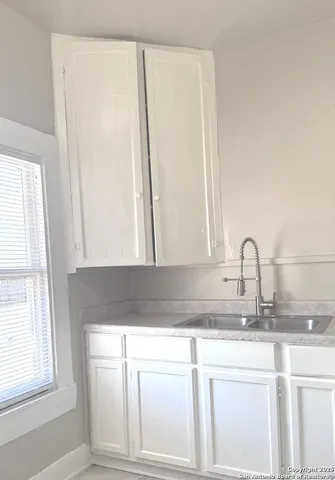 a kitchen with granite countertop white cabinets and a sink