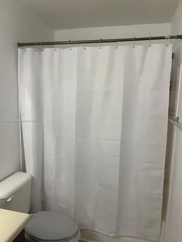 a bathroom with a shower curtain and a sink