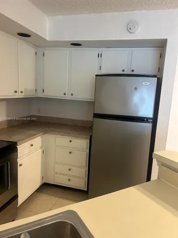 a kitchen with cabinets and white appliances