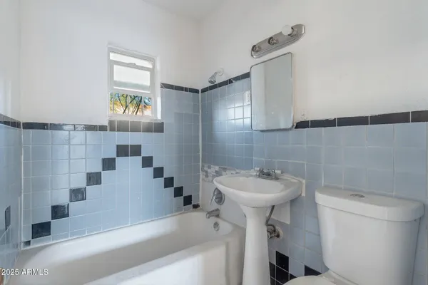 a view of an empty room with wooden floor and a ceiling fan