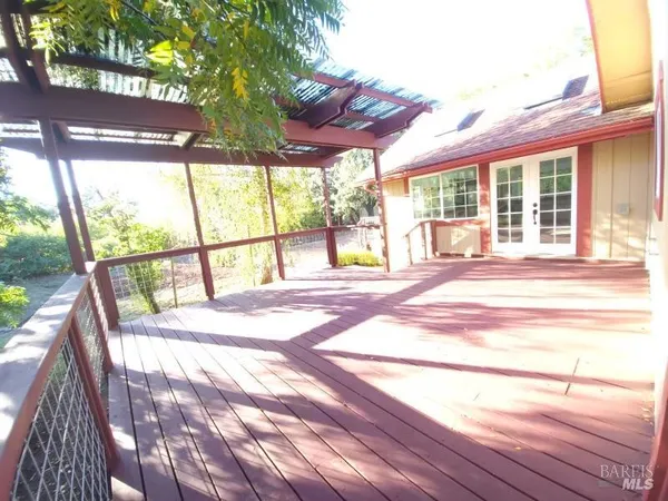 a view of a white house next to a road and yard