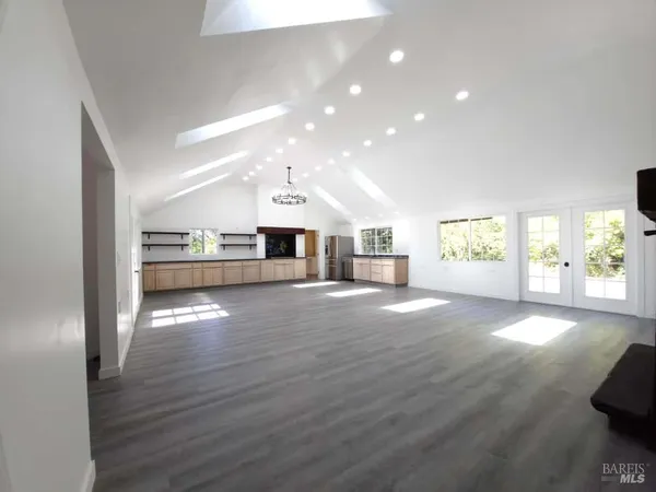 a view of a living room a kitchen island with wooden floor