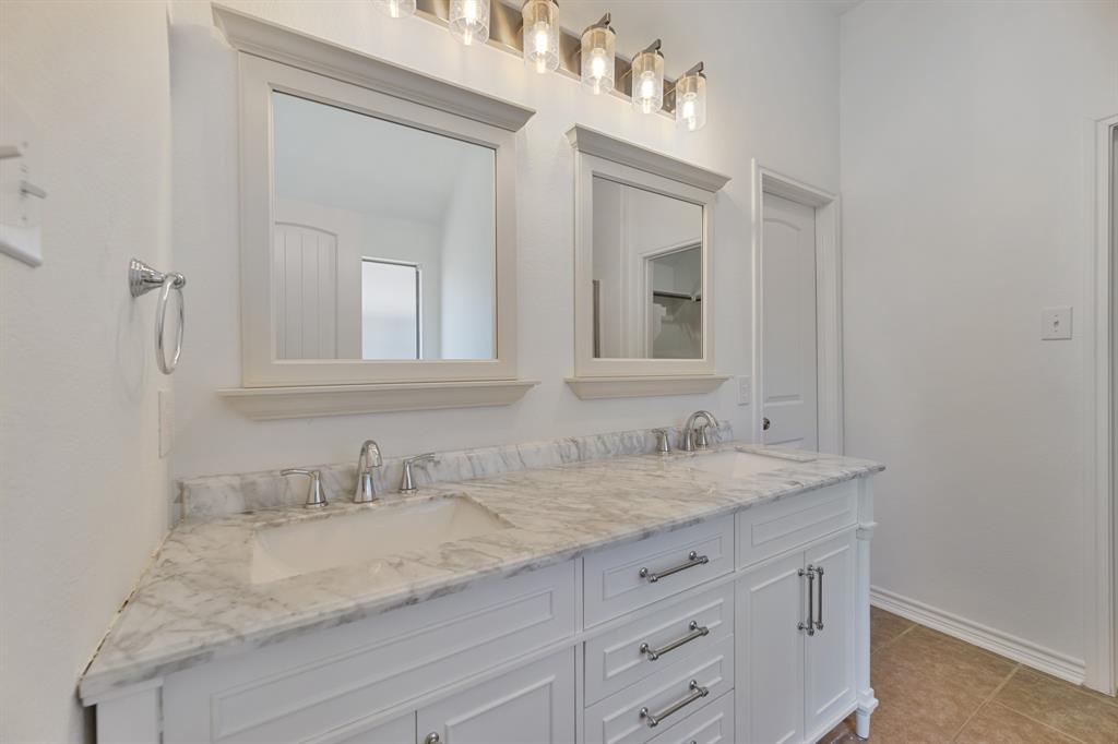 5129 Leeray Road Fort Worth, TX 76244 - Photo 2 of 39 a bathroom with a granite countertop sink and a mirror
