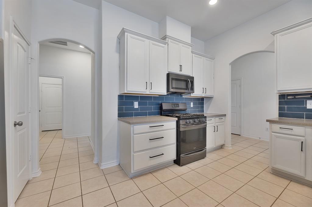 5129 Leeray Road Fort Worth, TX 76244 - Photo 30 of 39 a kitchen with stainless steel appliances a stove top oven and cabinets