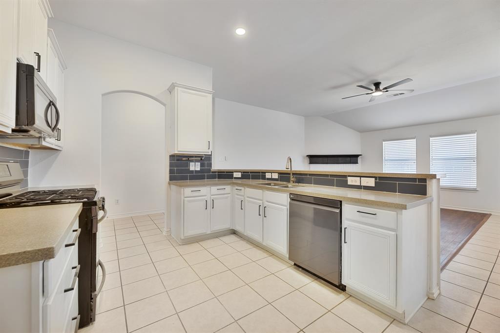 5129 Leeray Road Fort Worth, TX 76244 - Photo 6 of 39 a kitchen with granite countertop white cabinets and white appliances