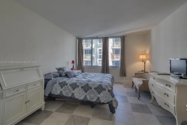 a bedroom with a bed and large windows