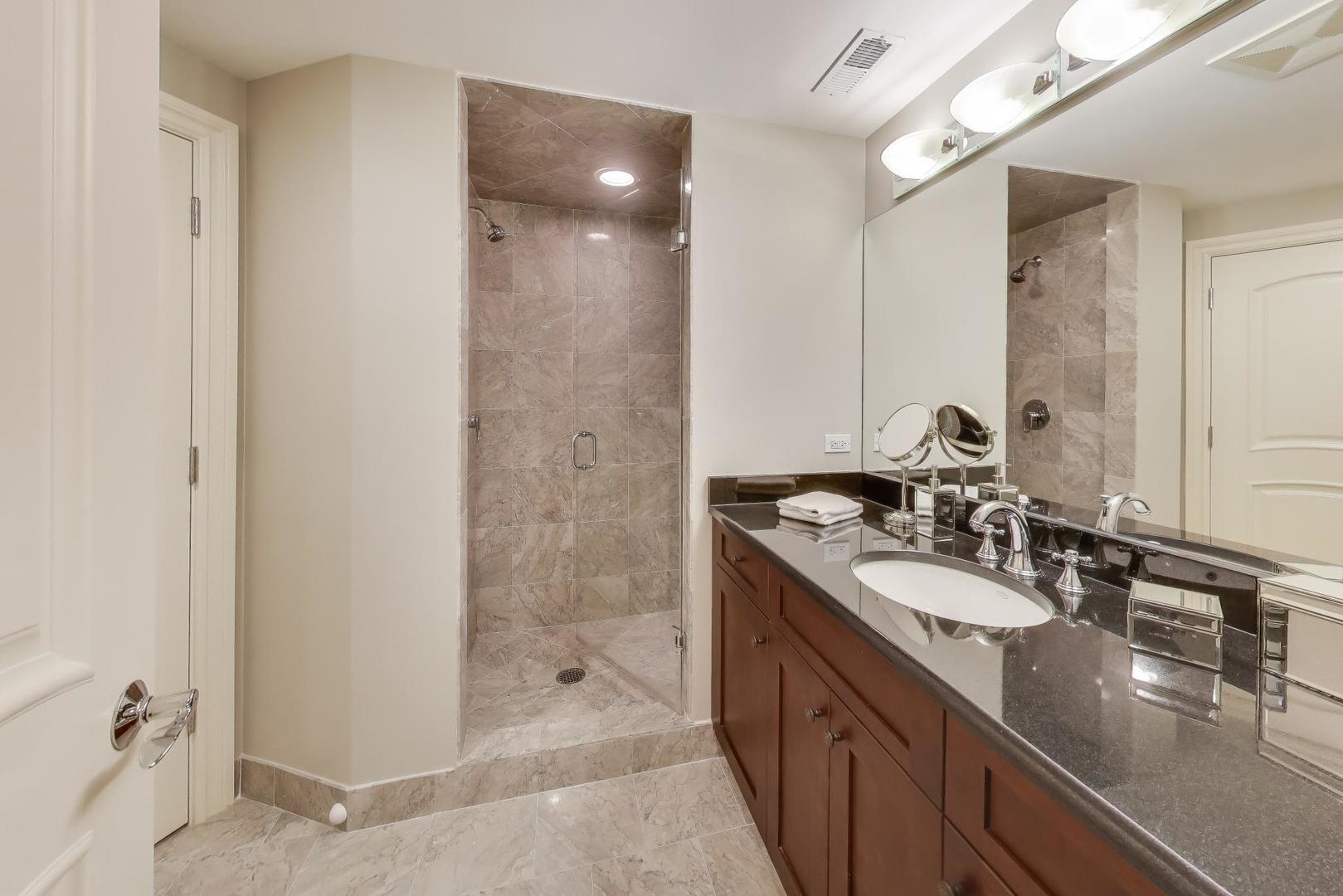 19 Meadowview Road Northfield, IL 60093 - Photo 50 of 65 a bathroom with a double vanity sink a mirror and shower