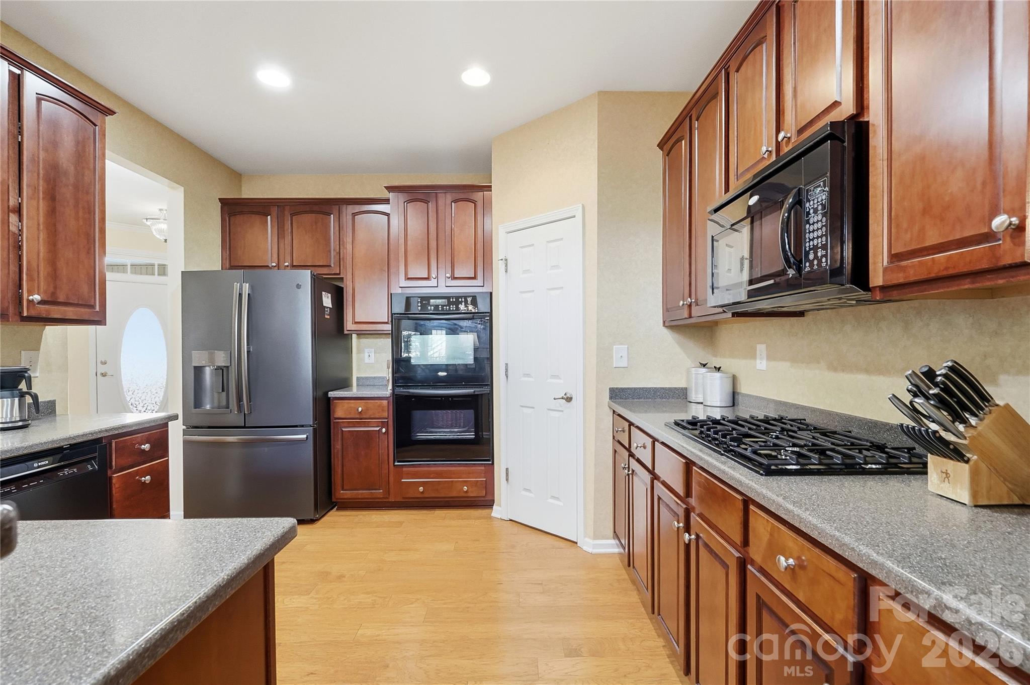 335 Garnet Court Fort Mill, SC 29708 - Photo 9 of 44 a kitchen with stainless steel appliances granite countertop a refrigerator a stove and a sink with wooden cabinets