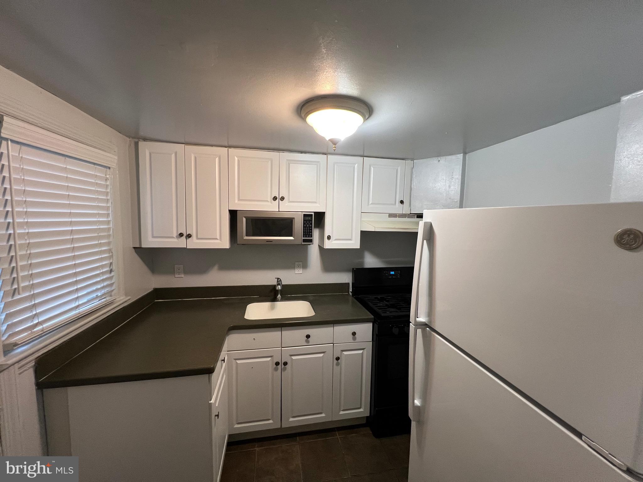 2581 Iverson Street Temple Hills, MD 20748 - Photo 4 of 13 a kitchen with appliances a sink and cabinets