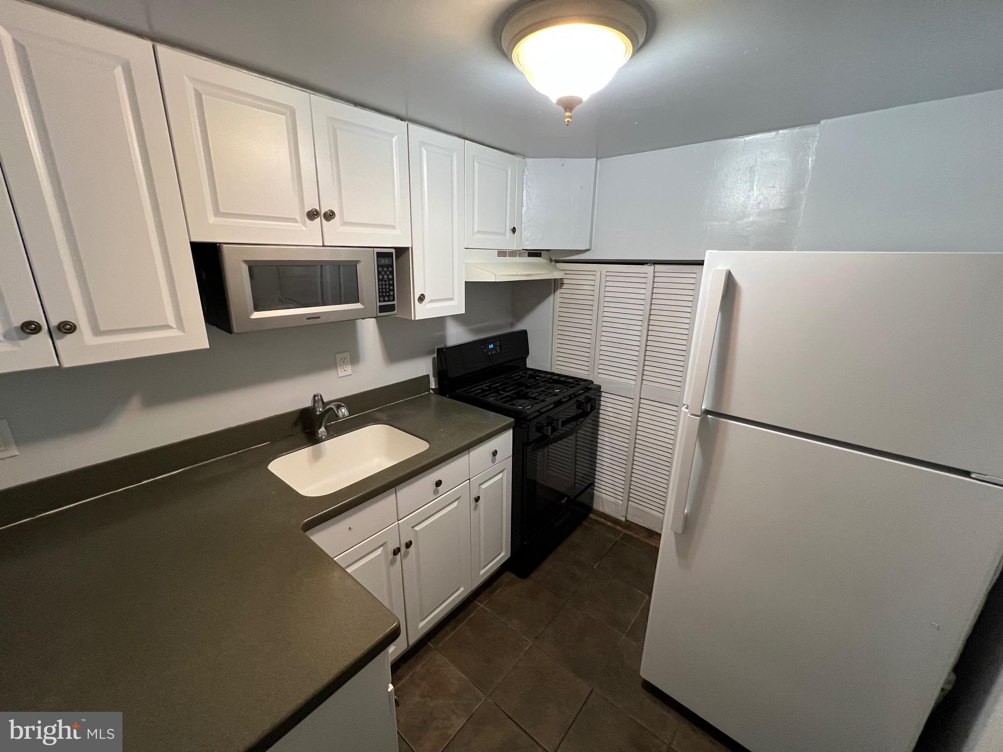 2581 Iverson Street Temple Hills, MD 20748 - Photo 5 of 13 a kitchen with a sink a stove a refrigerator and cabinets