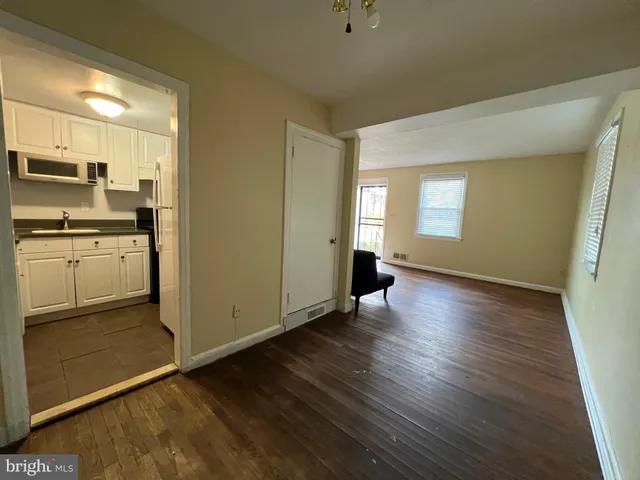 a view of a kitchen with wooden floor and electronic appliances