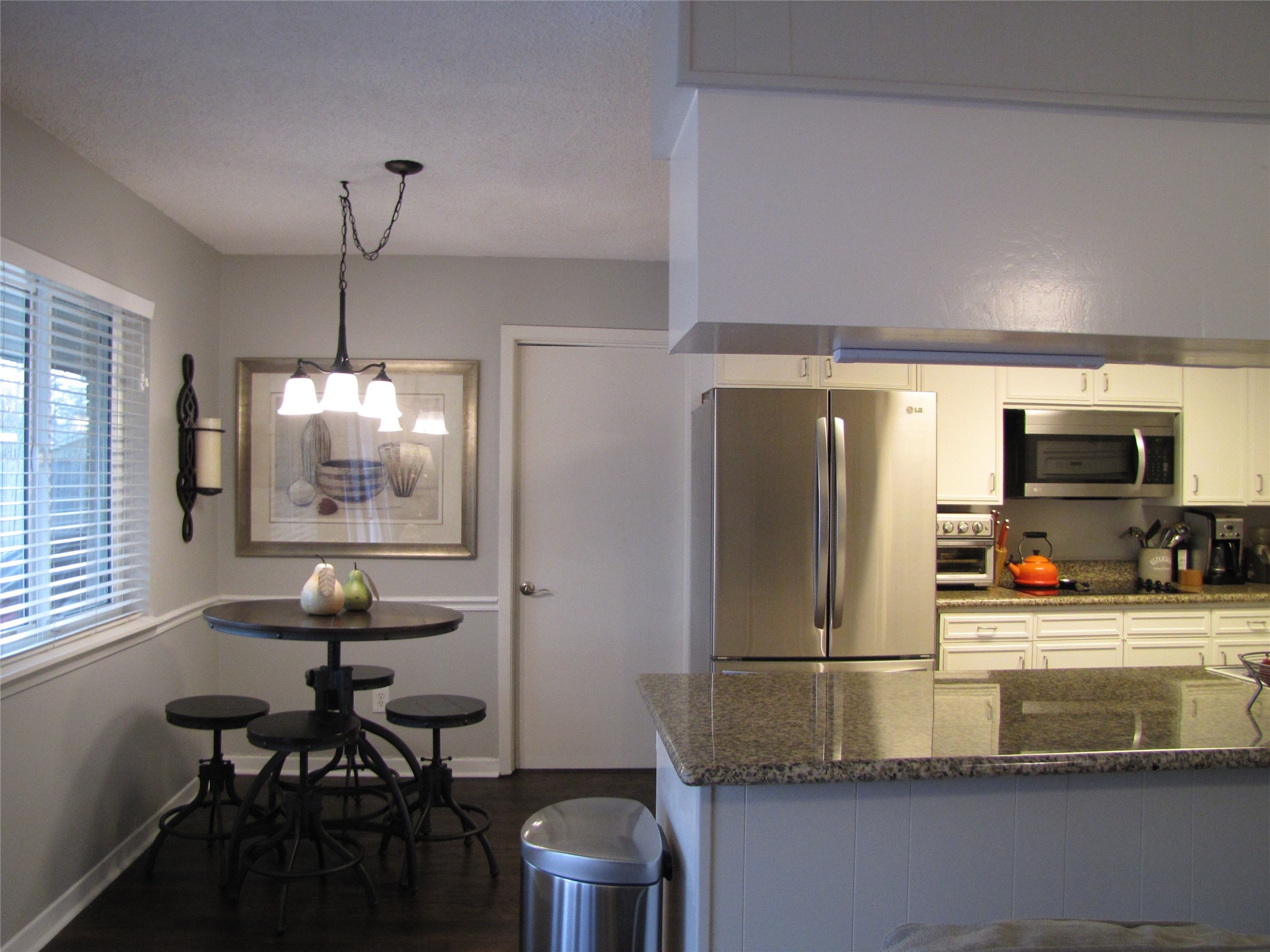 7902 Meadowcroft Drive Houston, TX 77063 - Photo 3 of 20 a kitchen with kitchen island a dining table chairs and a large window