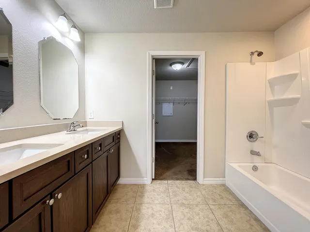a spacious bathroom with a bathtub sink and mirror
