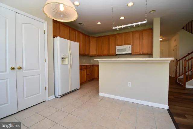 wooden floor in an empty room with a kitchen