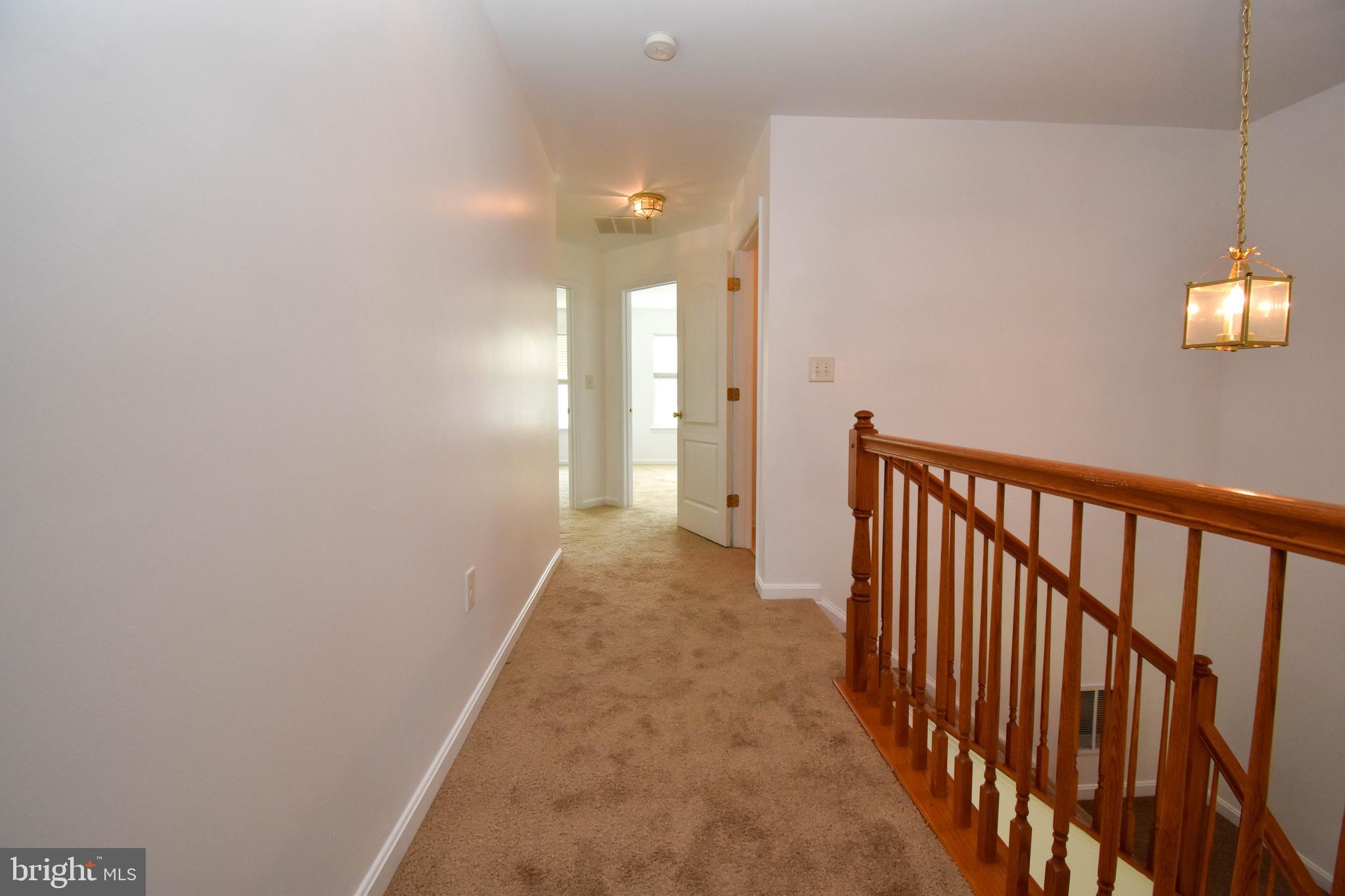 29549 Whitstone Lane, Unit 1305 Millsboro, DE 19966 - Photo 14 of 31 a view of a hallway with wooden floor and a window