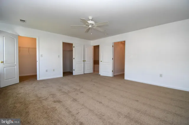 an empty room with closet and fan