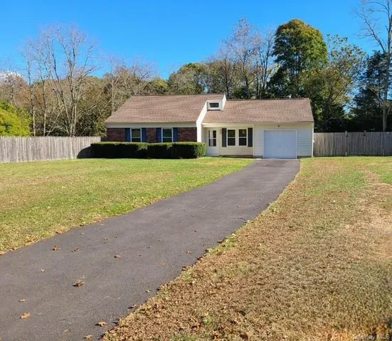 a aerial view of a house next to a yard with big trees