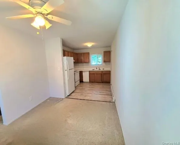 a view of a kitchen with a sink a refrigerator and window