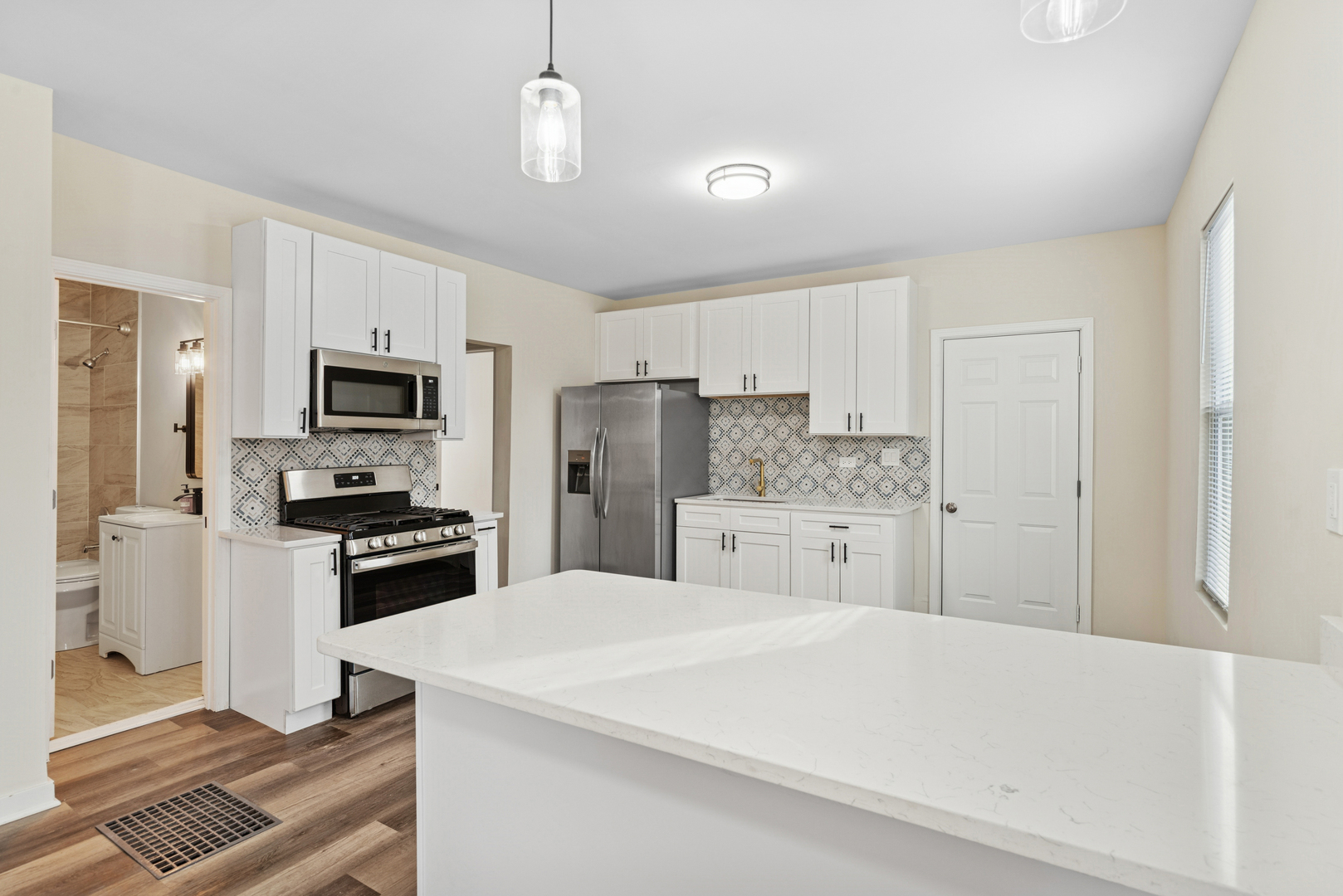 515 George Avenue, Unit 1 Waukegan, IL 60085 - Photo 5 of 15 a kitchen with stainless steel appliances a refrigerator stove microwave and cabinets