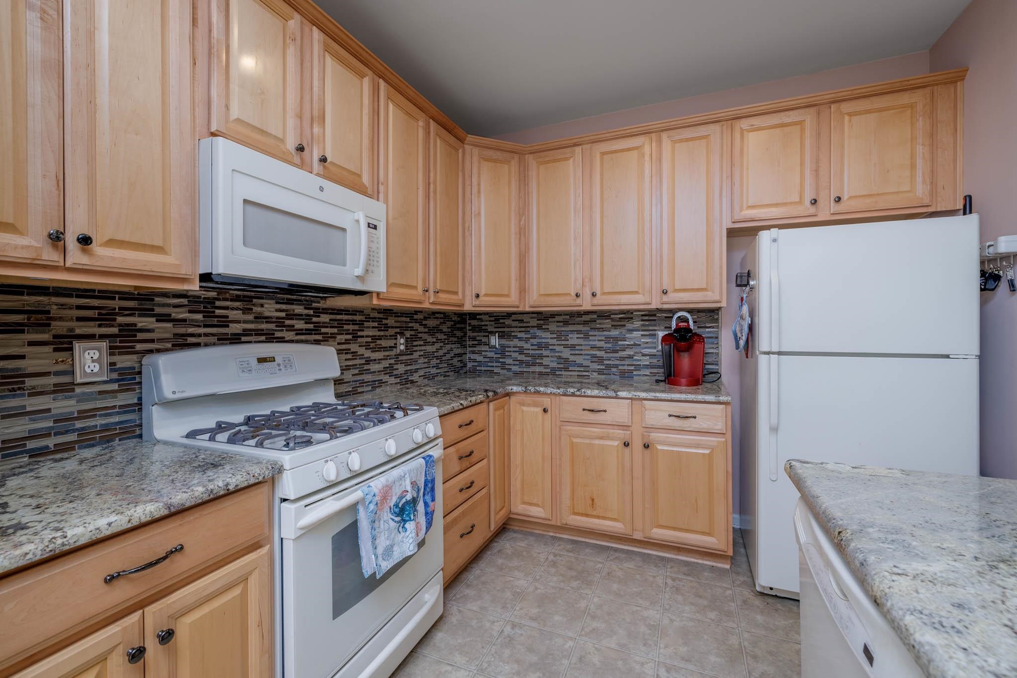 118 Aberdeen Way Rio Grande, NJ 08242 - Photo 15 of 35 a kitchen with granite countertop a sink stove and cabinets