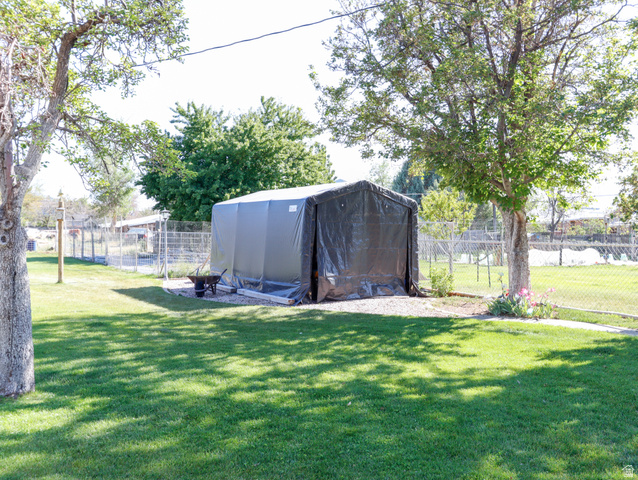 155 West Center Street Fillmore, UT 84631 - Photo 68 of 86 Expansive grassy yard featuring a large fabric-covered structure, mature trees, and a chain-link fence