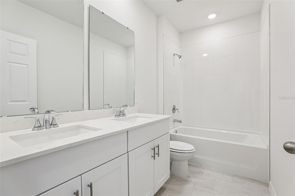 4018 Copperleaf Lane Kissimmee, FL 34759 - Photo 19 of 36 a bathroom with a granite countertop sink toilet and shower