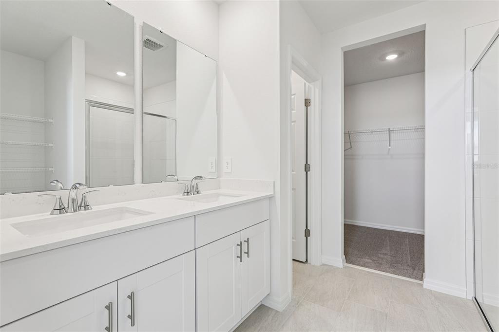 4018 Copperleaf Lane Kissimmee, FL 34759 - Photo 29 of 36 a bathroom with a double vanity sink and mirror