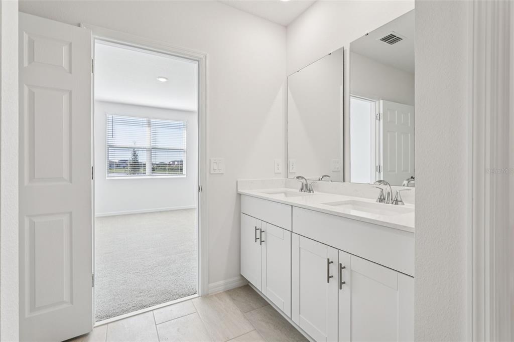 4018 Copperleaf Lane Kissimmee, FL 34759 - Photo 30 of 36 a bathroom with a double vanity sink mirror and