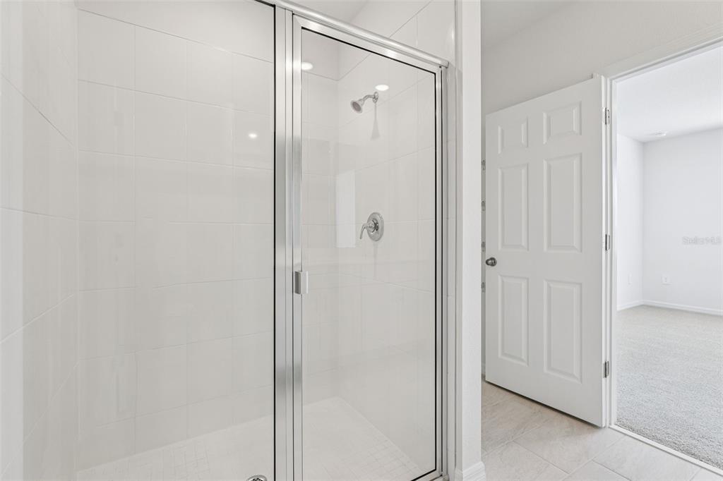 4018 Copperleaf Lane Kissimmee, FL 34759 - Photo 31 of 36 a bathroom with a glass shower door