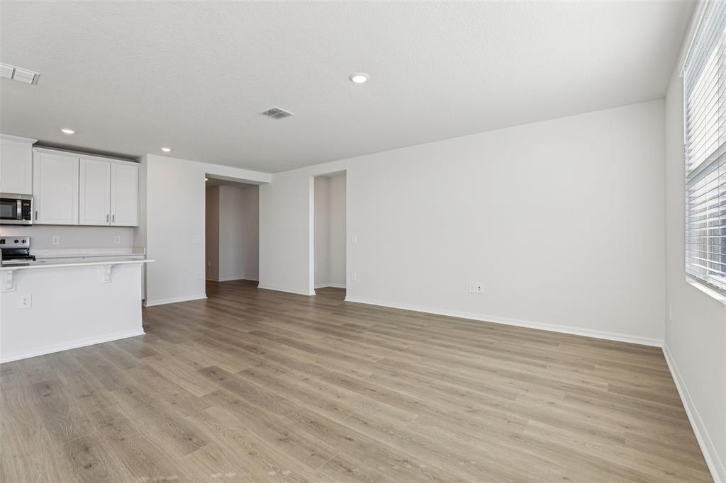 4018 Copperleaf Lane Kissimmee, FL 34759 - Photo 8 of 36 a view of an empty room with wooden floor and a window