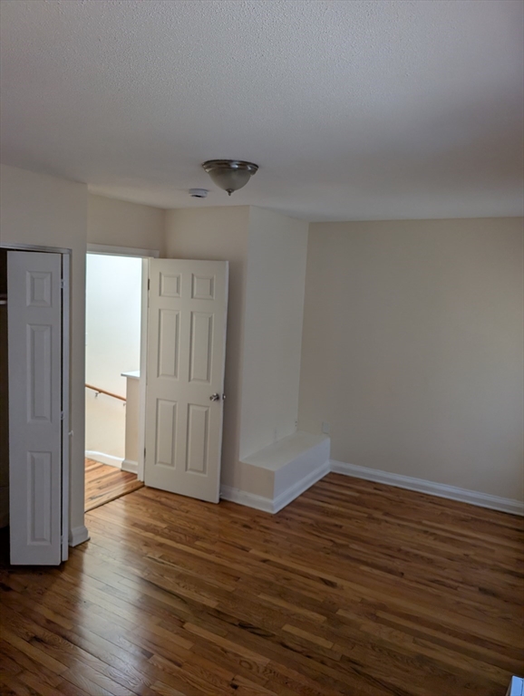 3 Presby Place, Unit 1 Boston, MA 02119 - Photo 4 of 5 a view of an empty room and wooden floor