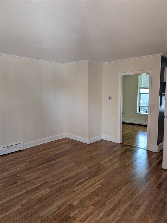 3 Presby Place, Unit 1 Boston, MA 02119 - Photo 5 of 5 a view of an empty room with wooden floor and a window