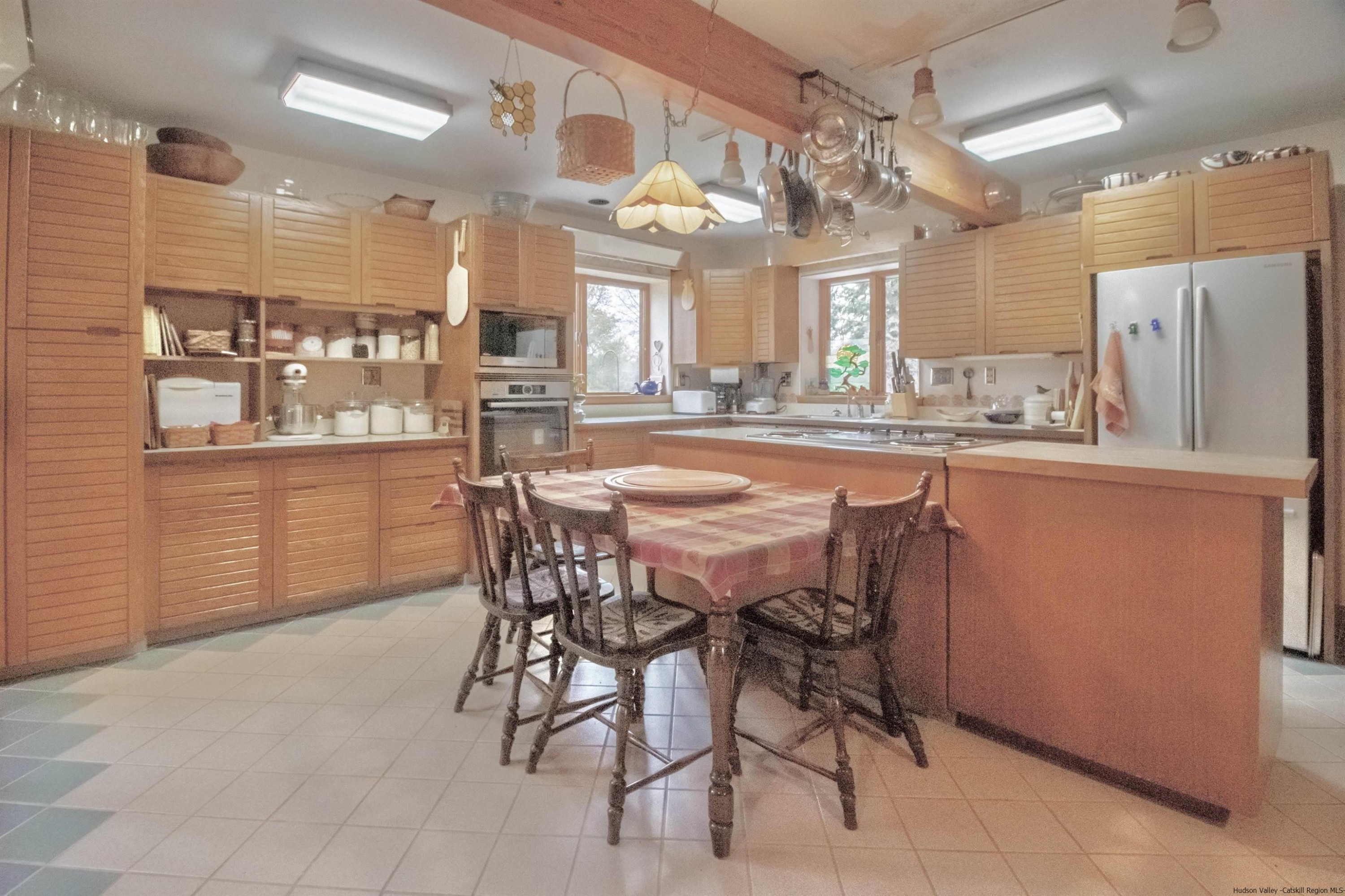 32 Mill Dam Road Stone Ridge, NY 12484 - Photo 3 of 33 a dining area with granite countertop a table chairs and wooden floor