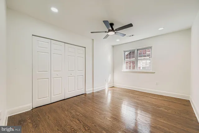 a view of an empty room with a window and a ceiling fan