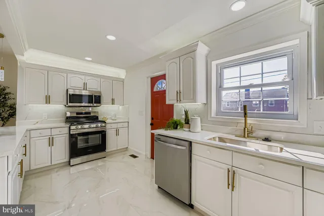 a kitchen with granite countertop a sink stainless steel appliances and window