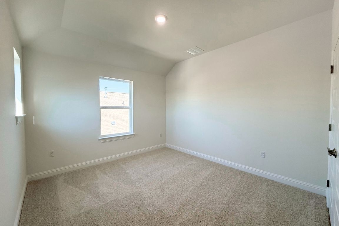 20301 Dustin Lane Pflugerville, TX 78660 - Photo 16 of 30 Carpeted empty room with baseboards and vaulted ceiling