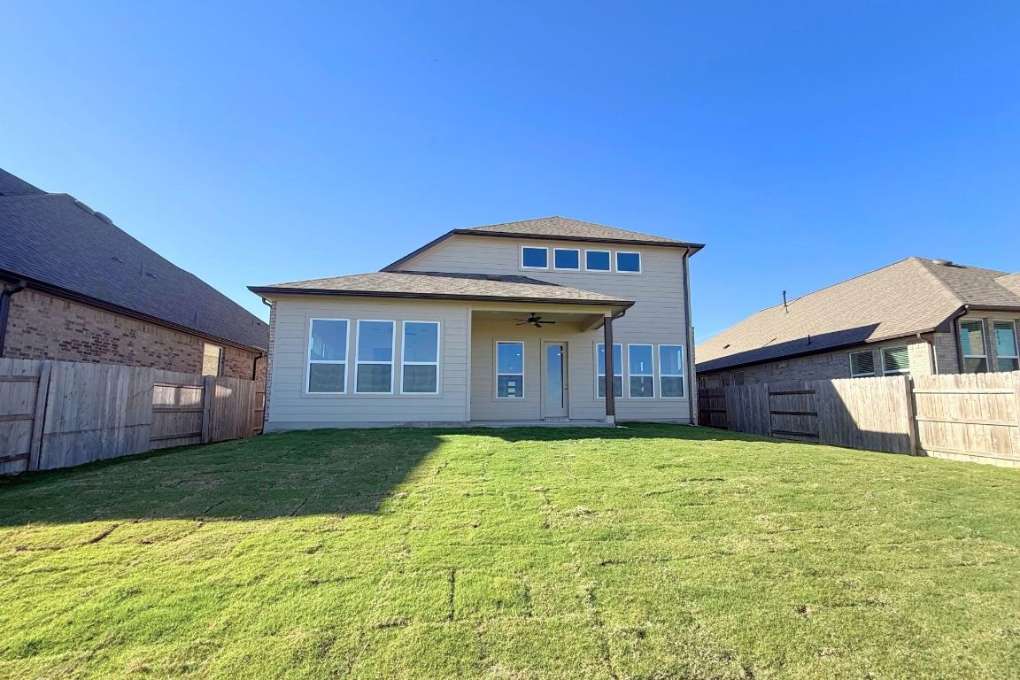 20301 Dustin Lane Pflugerville, TX 78660 - Photo 23 of 30 Rear view of house featuring a ceiling fan, a fenced backyard, and a patio