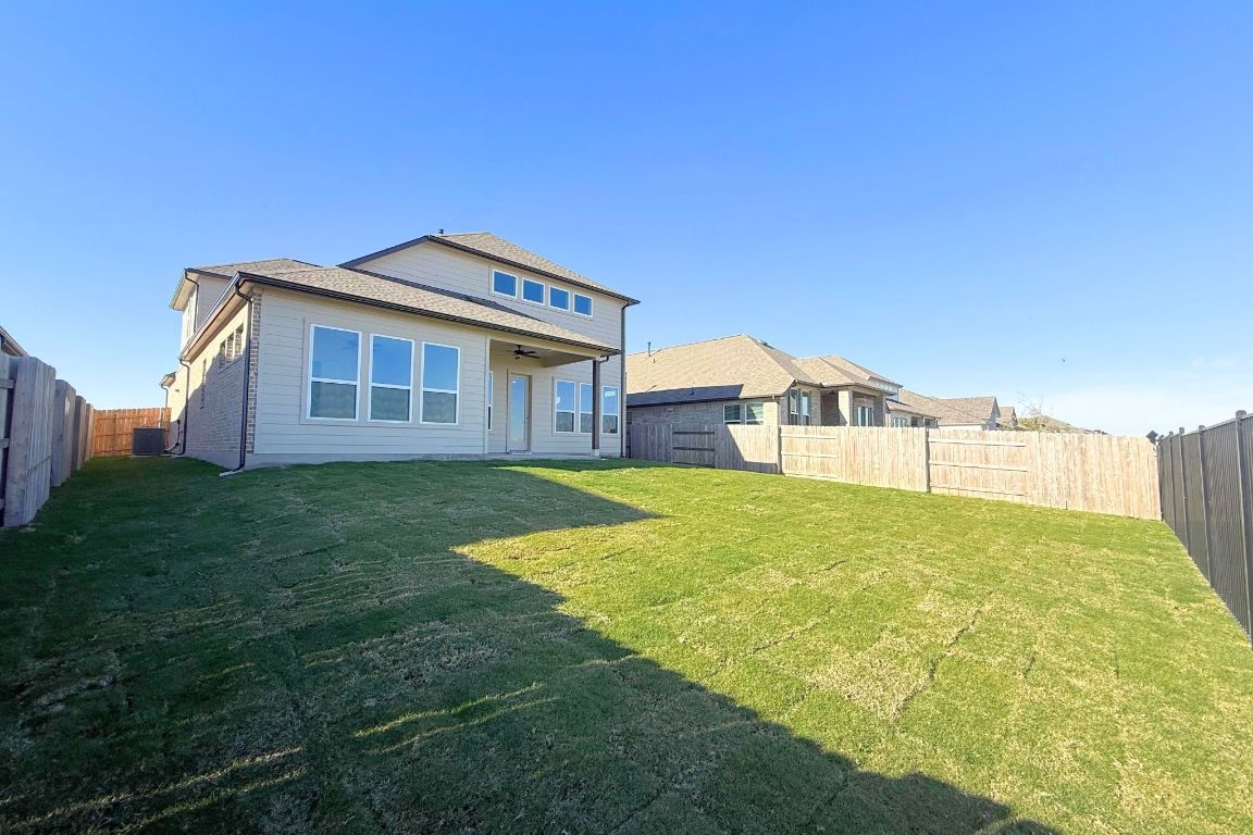 20301 Dustin Lane Pflugerville, TX 78660 - Photo 24 of 30 Rear view of house featuring a fenced backyard, ceiling fan, and a patio area