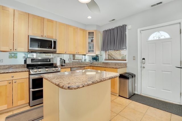 4714 South Evans Avenue, Unit 3N Chicago, IL 60615 - Photo 13 of 21 a kitchen with stainless steel appliances granite countertop a stove a sink and a microwave