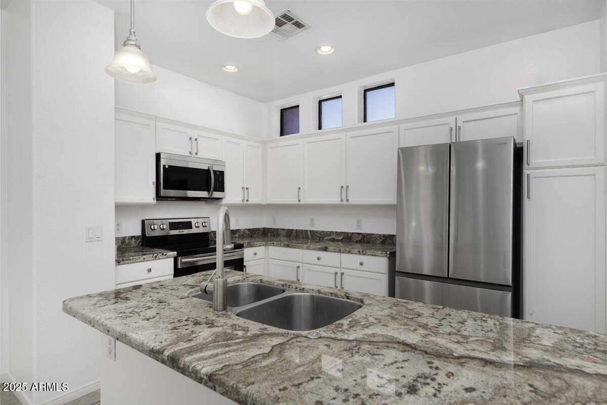 123 North Washington Street, Unit 22 Chandler, AZ 85225 - Photo 7 of 33 a kitchen with stainless steel appliances granite countertop a sink refrigerator and microwave