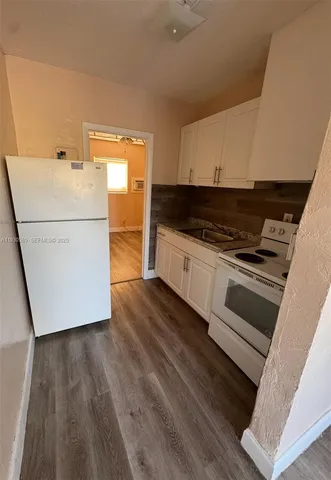 a kitchen with wooden floors and white appliances