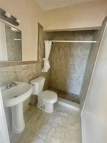 a bathroom with a toilet a sink and a shower