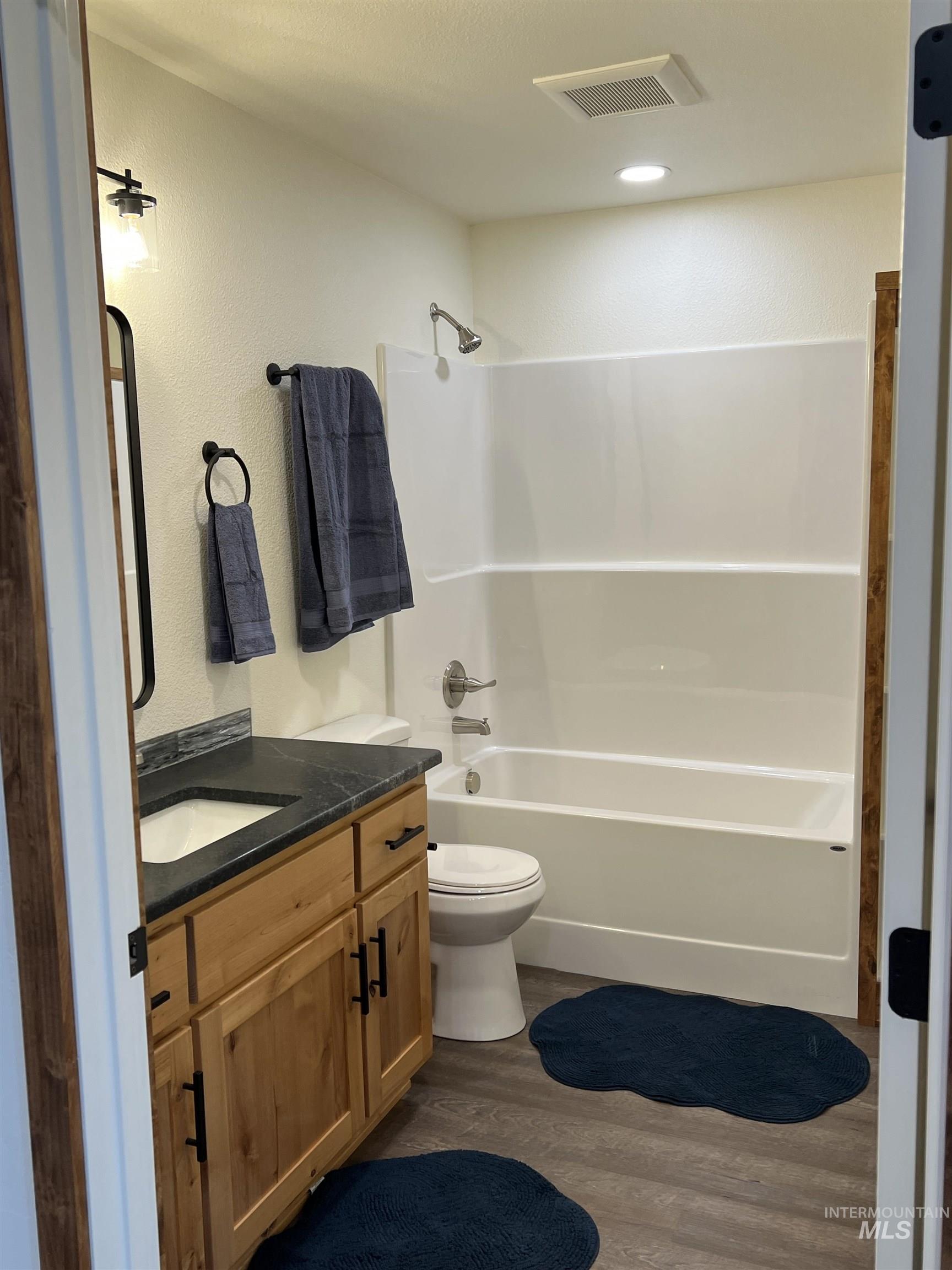 137 Angus Ranch Grangeville, ID 83530 - Photo 10 of 49 Full bath featuring dark wood-style flooring, shower / tub combination, vanity, and a textured wall