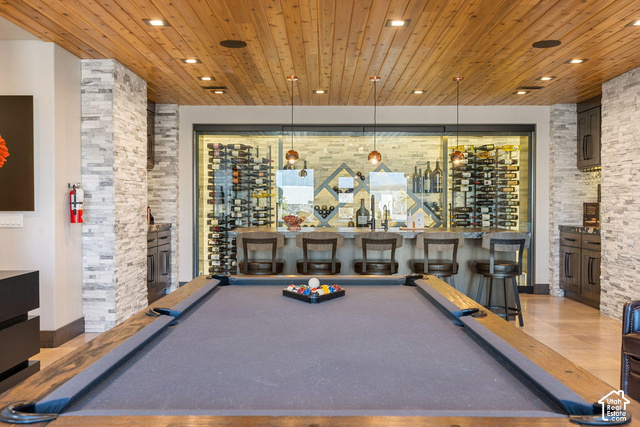 3652 South Cypress Road Hurricane, UT 84737 - Photo 5 of 81 Recreation room featuring a pool table, wood-paneled ceiling, stone accent walls, a built-in bar, and a glass-enclosed wine storage area