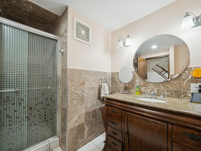 a bathroom with a granite countertop sink a mirror and vanity