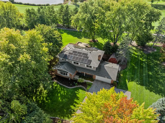 an aerial view of a house with a garden and lake view