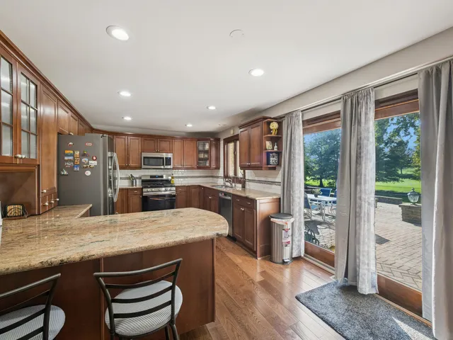 a large kitchen with kitchen island a large window in it